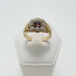 An early 19thC Memorial Ring, the front with eight seed pearls around central pink stone, with