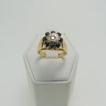 A sapphire and diamond cluster Ring, on raised textured shoulders in 18ct yellow gold, hallmarked