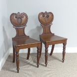 A pair of Victorian oak Hall Chairs, with shaped carved backs, solid seats supported by turned front