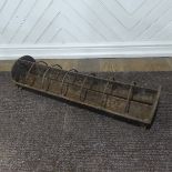 An antique cast iron pig feeder, W 95 cm x H 18 cm x D 25 cm.