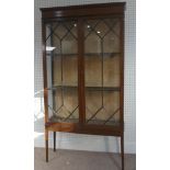 An Edwardian mahogany display cabinet, with inlaid decoration, having three shelves enclosed by