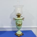 An Edwardian glass and gilt-metal oil lamp, with  moulded shade above a green opaque oviform lamp