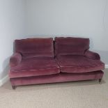 A good quality Howard style, club two seater sofa, upholstered in purple with some fading near the