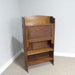 An Arts & Crafts oak upright bureau, having a pierced gallery back raised on a flared shelf atop a