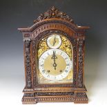 A attractive late 19th century continental carved walnut Mantel Clock, with arched brass dial,