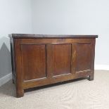 A large 18thC oak coffer, with hinged and panelled lid, and with triple panelled front, on plain
