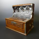 An Edwardian oak three-bottle tantalus, mirrored high-back with recess for housing the decanters,