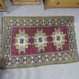 Tribal rugs; a Turkish Rug, hand-knotted with ochre geometric designs on a plum ground, worn,
