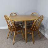 A 1960s Ercol blond elm Breakfast Suite, drop-leaf table, having oval fall leaves and raised on