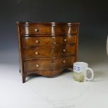 An Edwardian miniature serpentine-front Chest of Drawers, with decorative inlay and ivory handles, W
