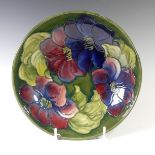 A Moorcroft pottery 'Clematis' pattern Bowl, in green ground with tubelined flowers, paper label and