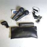 A Shure SM57 unidirectional dynamic Microphone with leather protective case and attachment, together