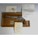 A Franklin Mint replica Wyatt Earp .44 Revolver with wood grips, a wooden display hanging frame,
