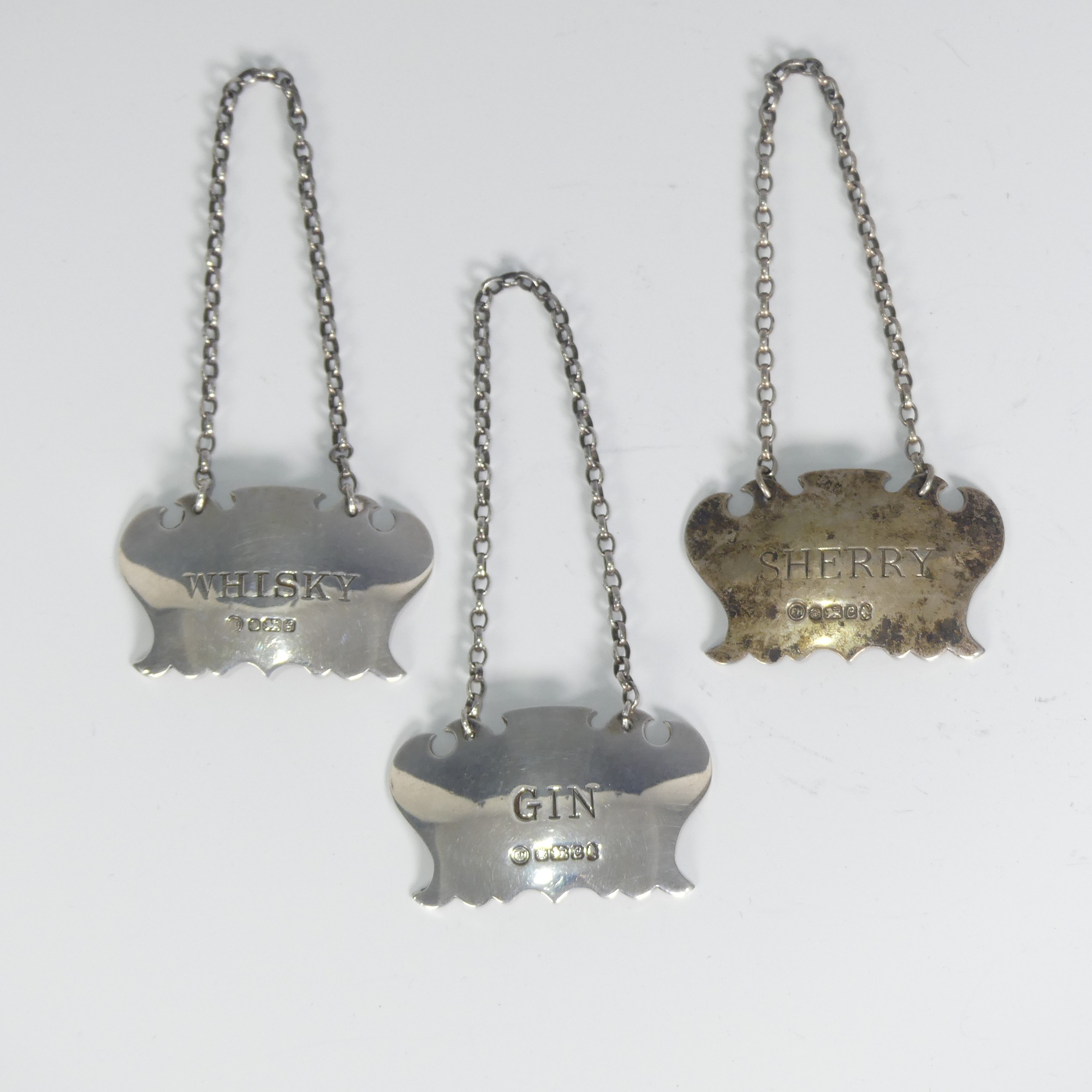 A set of three Elizabeth II silver Wine Labels, by Francis Howard Ltd., the Sherry and Gin