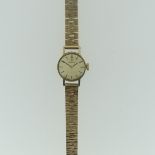 A 9ct yellow gold Omega lady's Wristwatch, with circular silvered dial, gold baton markers and