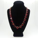 An antique graduated red paste Necklace, the oval facetted stones in closed back gilt metal mounts