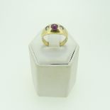 A ruby and diamond three stone Ring, the central circular cabochon ruby approx 4mm diameter with a