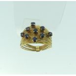 An 18ct yellow gold multi strand Ring, the front claw set with nine small sapphires, Size M, approx.