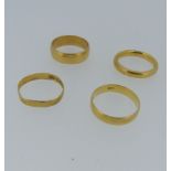 A 22ct yellow gold Band, Size M½, together with a wider 22ct gold band, Size M, and two others,
