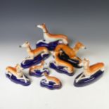 A pair of 19thC Staffordshire Greyhounds, with pierced aperture for pen stand, together with another