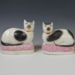 A pair of 19thC Staffordshire pottery Cats, the white ground with black colouration, modelled in a