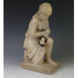 An alabaster sculpture of Cleopatra, modelled half nude, kneeling and with a brown snake coiled