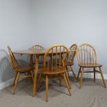 A 1960s Ercol blond elm drop-leaf Table, having oval fall leaves and raised on slightly tapering