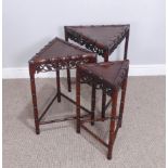 An unusual Chinese hardwood triangular nest of three Tables, frieze carved and pierced with grapes