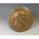 A late Victorian circular brass embossed Plaque, of a gentleman's bust within oak leaf wreath, engr