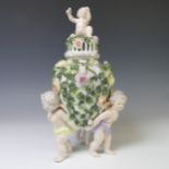 A Sitzendorf porcelain figural Pot Pourri Urn, with relief work floral encrusted body raised on