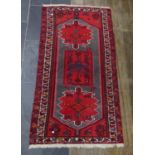 Tribal rugs; a hand-knotted Qashqai rug, with butterfly symbols and geometric designs on a red