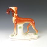 An antique Staffordshire pottery group of a Cow with its Calf, raised on moulded plinth, together