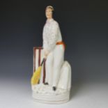 A 19thC Staffordshire pottery figure of a Cricketer, c. 1860, modelled as a batsmen at the wicket