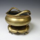 A Chinese gilt bronze Tripod Censer, of typical circular form with two loop handles, raised on three