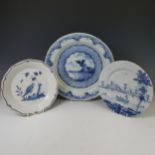 A 19thC Delftware Plate, depicting three figures in river landscape on a boat, D 22cm, together with