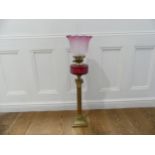 A Victorian brass and cranberry glass Oil Lamp, bearing TRS mark, the stepped base with corinthian