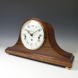 O.Comitti & son of London, a mahogany mantle Clock in 'Napoleon hat' style, raised on brass feet.