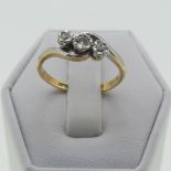 A small three stone diamond cross-over Ring, illusion set in 18ct yellow gold and platinum, Size