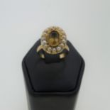 An antique citrine and seed pearl oval Cluster, in a closed back yellow metal mount, tests as