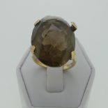 A facetted smokey quartz Ring, the oval stone approx 22.25mm long, four claw set in 9ct yellow gold,