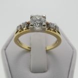 A 14ct gold and diamond Ring, the central brilliant cut stone approx. 0.65ct, four claw set in white
