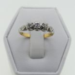 A small three stone diamond Ring, illusion set in 18ct yellow gold and platinum, Size K, 2.1g.