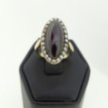 An early 19thC garnet and seed pearl cluster Ring, the oval cabochon garnet 20mm long, with seed