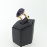 An oval cabochon amethyst Ring, 2cm long, mounted in 9ct rose gold, Size M, 7.2g.