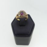 An early 20thC 'Suffragette' cluster Ring, the central purple garnet surrounded by eight cultured
