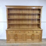 A large pine Dresser, three shelved plate rack with hooks, raised on large plinth dresser base, W