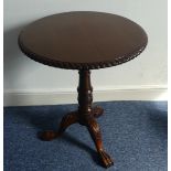 A reproduction tilt-top Wine Table, circular top raised on turned and carved column and claw feet, W
