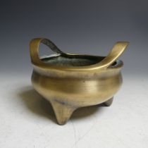 A Chinese bronze Tripod Censer, simplistic form flanked with two loop handles, with apocryphal