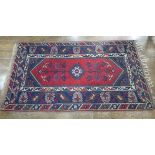 Tribal Rugs; a Turkish Rug, blue and red ground with tree of life patterns set within a geometric
