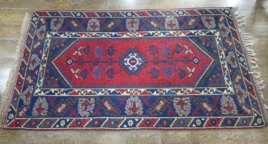 Tribal Rugs; a Turkish Rug, blue and red ground with tree of life patterns set within a geometric